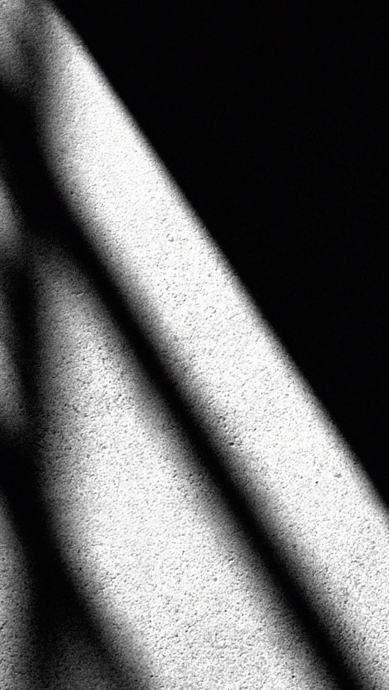 Diagonal stripes of light and shadow on a wall